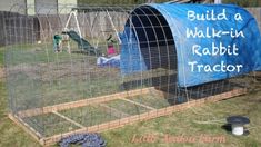 a chicken coop with a blue cover on top and a child laying in the background