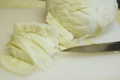 a knife and some white cabbage on a cutting board