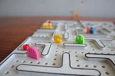 a close up of a board game on a table with many different colored pins and shapes