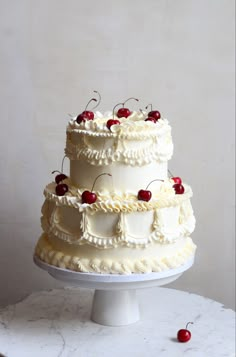 a three tiered cake with cherries on top