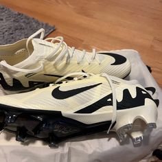 a pair of white and black nike shoes on top of a piece of luggage next to a rug