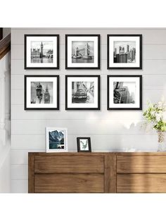 black and white photographs hang on the wall above a dresser