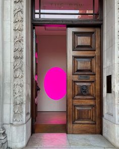 an open door with a pink circle painted on the front and side wall behind it