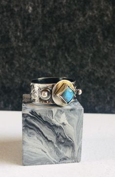 I handcrafted this silver ring and set a pretty square labradorite on top and two small silver balls on either side of the labradorite. I textured the silver band. I patinated the ring and then buffed off some of the patina to give the ring a two tone look.  1 Only **Size 8** -Labradorite 6mm square -925 Sterling Silver  I handcraft each piece of jewellery one piece at a time in my garden studio. Each piece comes wrapped in anti-tarnish paper and sat inside a paper box. Message me for any questi Silver Labradorite Hand Forged Rings, Hand Forged Silver Labradorite Rings, Unique Silver Labradorite Ring, Rings In Silver, Dendritic Opal, Garnet Bracelet, Garden Studio, Textured Ring, Handcrafted Rings