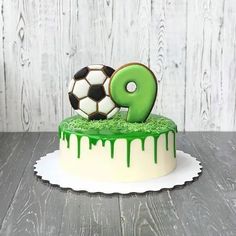 a birthday cake with green icing and a soccer ball on top that says 9