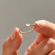 a woman holding a diamond ring in her hand