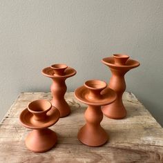 three clay vases sitting on top of a wooden table