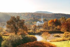 an image of a church in the middle of trees and grass with water running through it