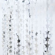 some white stars hanging from the side of a window