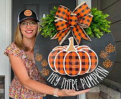 a woman is holding up a sign that says they're pumpkins and has a bow on it