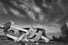 a black and white photo of a building that has been blown over by the wind