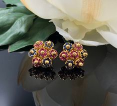 "These 18K yellow gold cluster earrings are set with natural rubies and sapphires creating a floral design. Each cluster is attached so that they are articulated and move subtly with the wearer. The earrings were originally fitted with screw backs, but the owner had them converted to pierced earrings in the 1980s. The posts and push backs are in 14K yellow gold, and stamped 14K. These earrings are truly beautiful and guaranteed to turn heads! To see a complimentary ring from the same estate clic Elegant Multicolor 22k Gold Earrings, Cluster Earrings, Floral Earrings, Natural Ruby, Pierced Earrings, Emerald Diamond, Emerald Ring, Vintage Costumes, Estate Jewelry