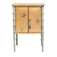 an old wooden cabinet with butterflies painted on the doors and drawers, against a white background