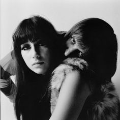 black and white photograph of two women embracing each other with fur stolers on their shoulders