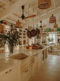 a kitchen filled with lots of pots and pans hanging from the ceiling next to a sink