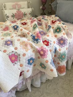 the bedspread is made with many different colored flowers on them and are next to each other