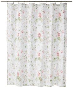 a shower curtain with pink and green flowers on white fabric, hanging from a metal rod