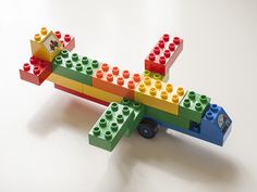 a toy airplane made out of legos on a white surface with the top part missing