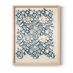 an art work with blue and white flowers in the center, framed on a wall