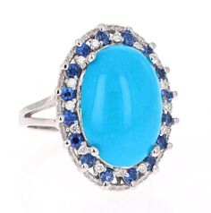 Ring Attributes: Oval Cut Turquoise = 6.48 Carats. 16 Sapphires = 0.79 Carats. 16 Round Cut Diamonds = 0.18 Carats. (Clarity and Color: VS2 - H).   Total Carat Weight = 7.45 Carats.  14K White Gold = 7.4 Grams. Ring Size = 7 (Free ring sizing available) Formal Blue Oval Turquoise Ring, Luxury Blue Turquoise Ring For Formal Occasions, Oval Blue Turquoise Ring In Fine Jewelry Style, Oval Blue Turquoise Ring Fine Jewelry, Luxury Blue Multi-stone Turquoise Ring, Formal Turquoise Multi-stone Rings, Luxury Blue Oval Cabochon Turquoise Ring, Oval Blue Multi-stone Turquoise Ring, Fine Jewelry Blue Turquoise Cabochon Ring