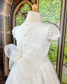 A delicate and traditional first communion gown for girls, it is made with lightweight organza in off-white. It has beautiful details throughout the dress. It has buttons on the back for closure and a bow. Dry clean Made in Spain Final sale, no exchanges nor returns are available Organza Baptism Dress With Lace Bodice For First Communion, Organza Baptism Dress With Bow, Organza First Communion Dress With Ruffles, First Communion Dress With Lace Bodice And Organza, Organza Dress With Bow For Baptism, Elegant Organza Dress For First Communion, Organza Baptism Dress With Lace Bodice For Confirmation, Organza Baptism Dress With Lace Bodice, First Communion Dress With Lace Bodice In Organza