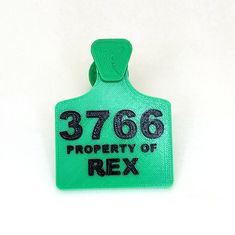 a green tag with the number 3766 property of rex on it's side