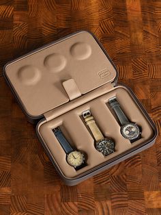 an open suitcase with three watches in it