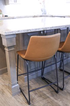 two brown chairs sitting on top of a kitchen counter