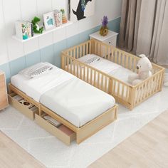 two wooden cribs with mattresses and drawers in a child's room