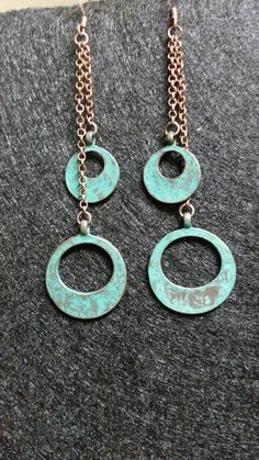 A pair of dangle earrings with teal and copper marble circles and copper chains Metal Drop Earrings With Patina, Copper Dangle Jewelry With Patina, Multicolor Copper Dangle Earrings, Turquoise Dangle Earrings With Patina, Copper Dangle Earrings With Patina, Antique Finish Copper Dangle Earrings, Teal And Copper, Turquoise Dangle Brass Earrings, Copper And Marble