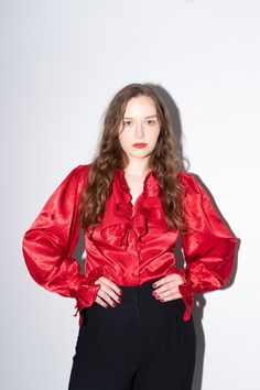 Vintage red bold satin blouse with ruffles from 2000s. Button closure, long puff sleeves with ruffled cuffs and a V neckline with big voluminous ruffles too. Truly eye-catching statement piece. BRAND - NLY Trend, Sweden MATERIAL - 70s viscose 30% nylon CONDITION - Excellent vintage condition SIZE - M Model is size M, 5'6" (171cm) MEASUREMENTS - Shoulder 14.9" (37cm) - Chest 36" (92cm) - Waist 34" (86cm) - Length 22" (55cm) - Sleeve 28" (72cm) Please note that this is a vintage item and may show Red Satin Party Blouse, Fall Satin Top With Ruffles, Fall Satin Ruffled Tops, Fall Satin Ruffle Tops, Red Ruffled Blouse For Formal Occasions, Red Puff Sleeve Blouse With Ruffles, Formal Satin Blouse With Ruffles, Blouse Elegant, Satin Bluse