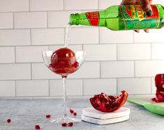 someone pours pomegranate into a wine goblet and garnish