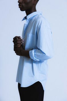 An ultra-crisp button up shirt with the effortless proportions of 90's Wall Street. Worn untucked or half-tucked, this oversized, billowy office staple makes for the ultimate off-duty move. Constructed from 100% pima cotton, a superior high-grade cotton known for it's incredible softness. Blue Relaxed Fit Dress Shirt For Work, Blue Relaxed Fit Shirt For Office, Oversized Button-up Tops For Business, Oversized Blue Top For Office, Oversized Classic Tops For Business Casual, Oversized Business Tops With Button Cuffs, Oversized Business Tops With Button Closure, Modern Oversized Shirt, Modern Oversized Shirt For Office