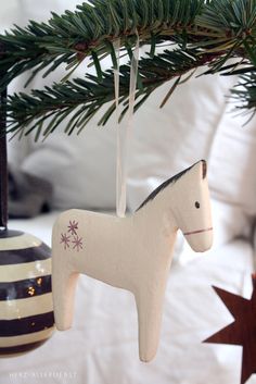 a wooden horse ornament hanging from a christmas tree