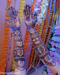 two hands decorated with henna and flowers