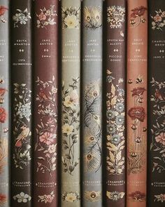 a row of books sitting on top of each other in front of a wall filled with flowers