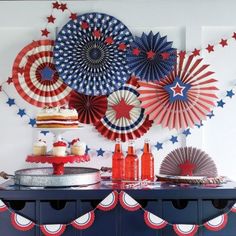 an american flag themed party with red, white and blue paper fan decorations on the wall