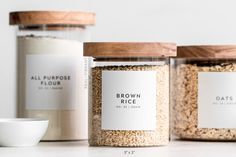 three jars filled with brown rice sitting on top of a white counter next to a bowl