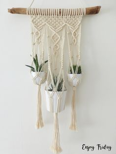 a macrame hanging from a wall with potted plants