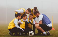 a group of young men standing next to each other in front of a soccer ball