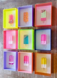 ice creams and popsicles are arranged in square boxes on the wall, with different colors