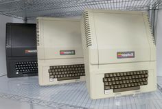 two old computers sitting on top of a shelf