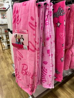 pink towels are hanging up in a store