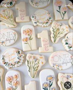 decorated cookies are arranged in the shape of numbers and flowers on a white tablecloth