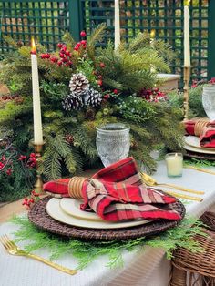 the table is set with plaid napkins and place settings