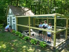 three children standing in front of a chicken coop