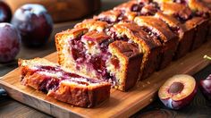 sliced plum bread on a cutting board next to fresh plums