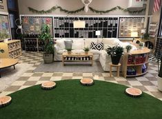 a living room filled with furniture and lots of plants on the floor in front of a checkerboard wall