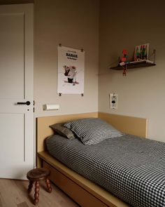 a small bedroom with a bed, nightstand and pictures hanging on the wall above it