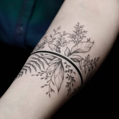 a woman's arm with a black and white tattoo design on the left forearm